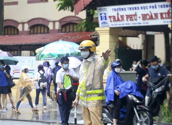 Lực lượng công an điều tiết, phân luồng giao thông tránh ùn tắc tại điểm thi trường THPT Trần Phú (quận Hoàn Kiếm). Ảnh: Tuấn Đức - TTXVN