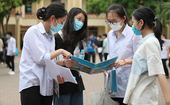 Thí sinh trao đổi bài thi sau khi kết thúc môn thi. Ảnh: Bích Huệ - TTXVN