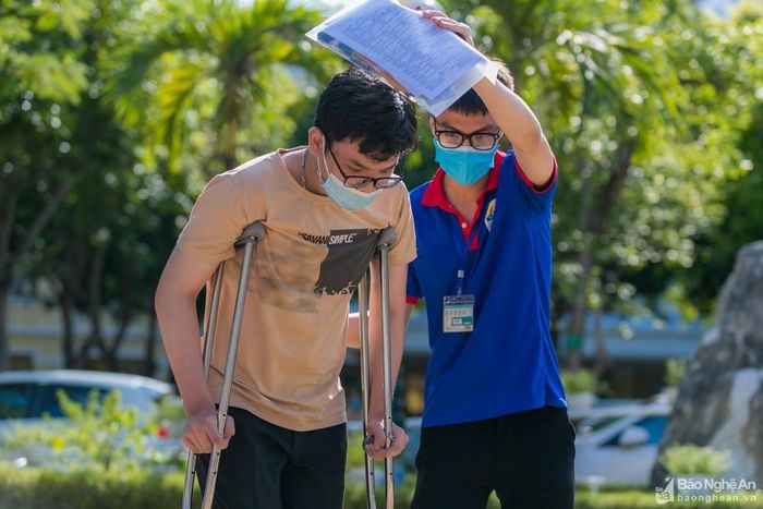 Sinh viên tình nguyện hỗ trợ 1 thí sinh bị tai nạn tại điểm thi Trường THPT Lê Viết Thuật. Ảnh: Đức Anh