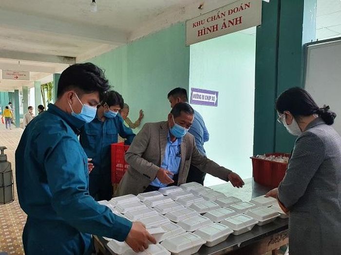 Các thành viên của bếp ăn tình thương chuẩn bị suất ăn cho người dân trong bệnh viện. Ảnh: VGP/Minh Trang