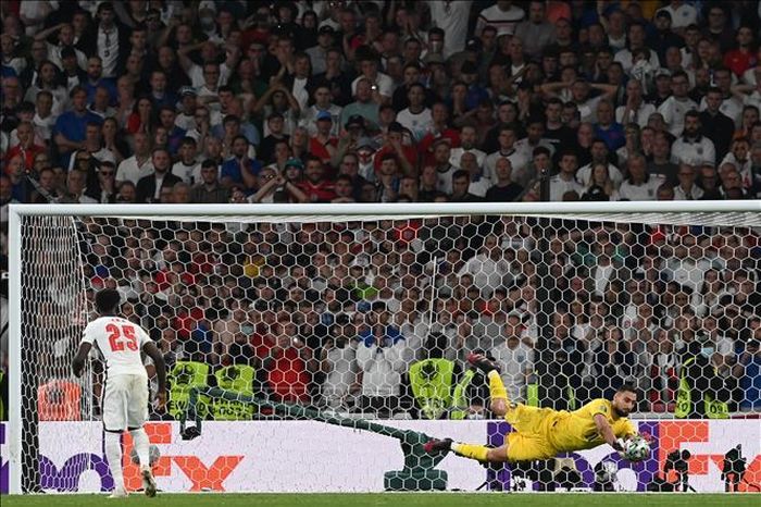 Thủ thành Italy Gianluigi Donnarumma (phải) cản phá thành công quả sút luân lưu của tiền vệ tuyển Anh Bukayo Saka (trái) trong trận chung kết EURO 2020 trên sân Wembley, London (Anh) ngày 11/7/2021. Ảnh: AFP/TTXVN
