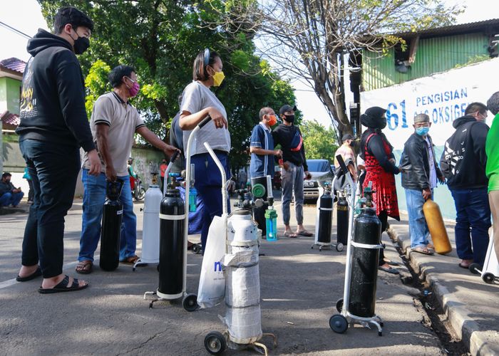 Người dân thủ đô Jakarta của Indonesia xếp hàng dài chờ nạp khí thở vào bình. Ảnh: Reuters.