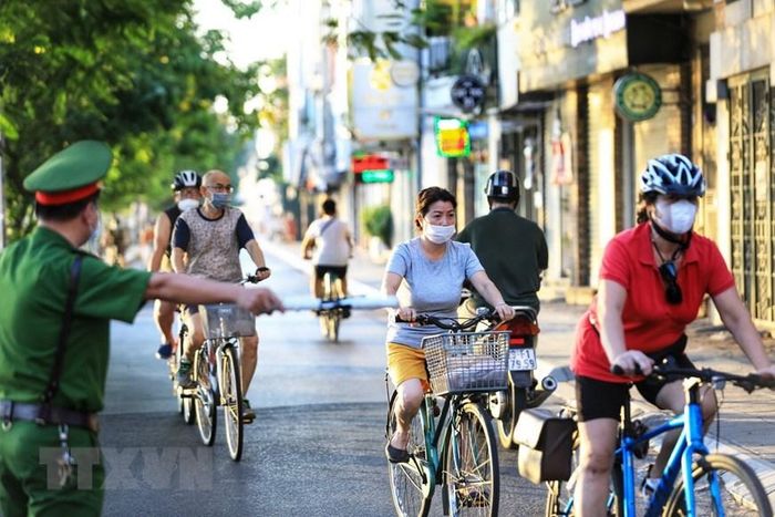  Lực lượng công an phường Thụy Khuê nhắc nhở người dân quay đầu không tụ tập đạp xe tập thể dục tại đường Nguyễn Đình Thi - chụp 6h sáng 16/7. (Ảnh: Thành Đạt/TTXVN) 