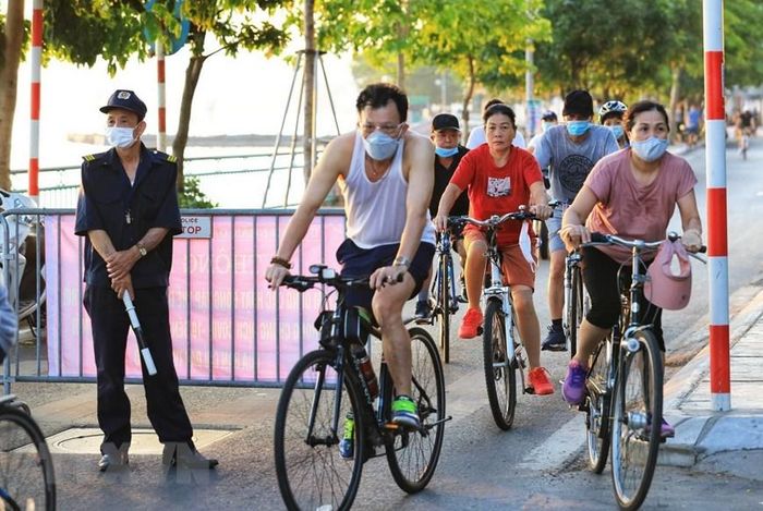  Lực lượng dân phòng cũng đành bó tay trước dòng người đạp xe tập thể dục băng qua đây dù đã lập rào chắn tại đường Nguyễn Đình Thi. (Ảnh: Thành Đạt/TTXVN) 
