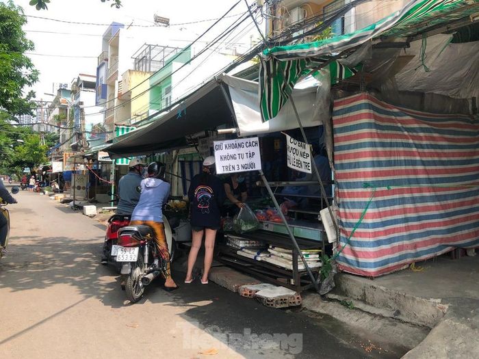 Điểm bán rau củ tự phát này dù thông báo giữ khoảng cách, không tụ tập trên 3 người, nhưng lại đang có tới 5 người đứng san sát nhau.