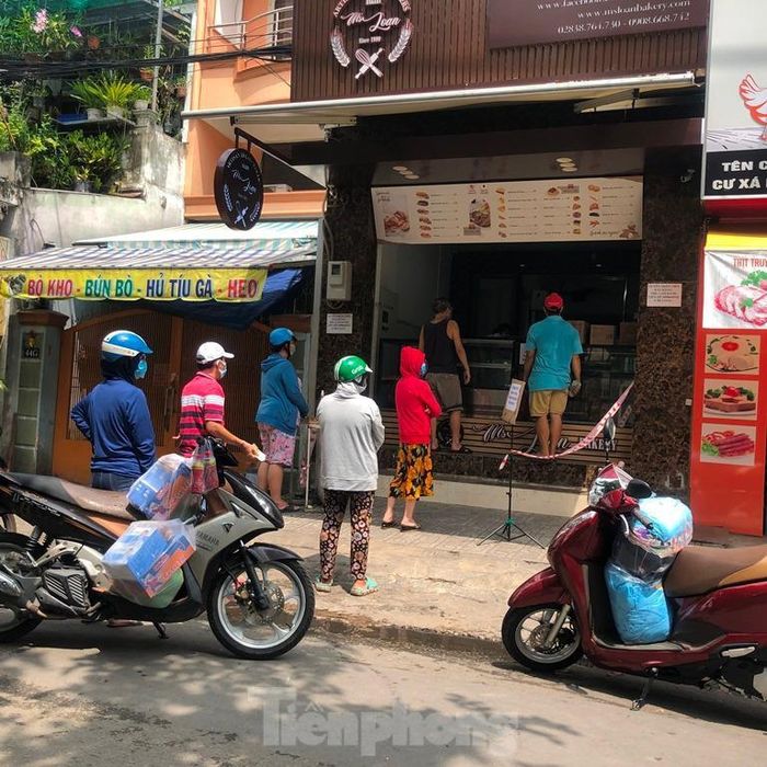 Một tiệm bán bánh mì chuyển hướng kinh doanh thịt, khách xếp hàng chờ mua.