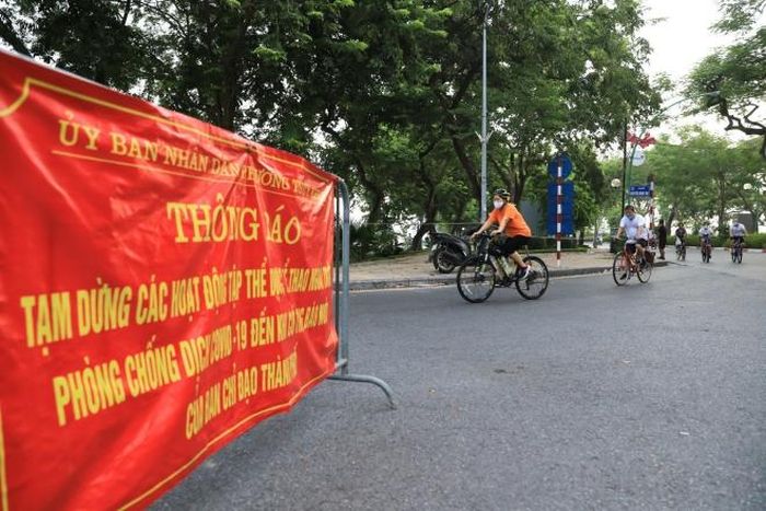 Mặc biển cấm và rào chắn người dân vẫn đạp xe tập thể dục trên đường Thanh Niên dọc hồ Tây (Ảnh chụp 5h30 sáng 19/7)