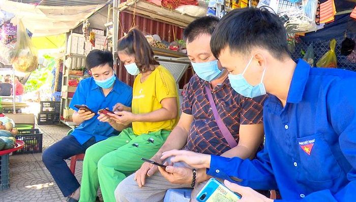 Đoàn viên thanh niên thị trấn Lăng Can (Lâm Bình) hỗ trợ người dân cải đặt và sử dụng ứng dụng khai báo y tế điện tử.