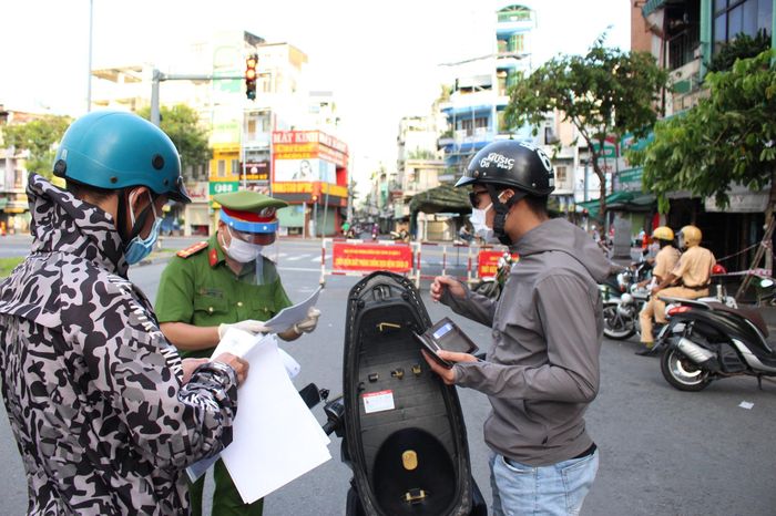 Lực lượng chức năng kiểm tra những người lưu thông trên đường trong thời gian cách ly xã hội.