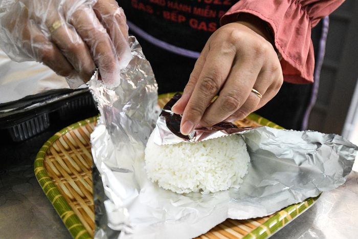  Riêng phần cơm được bọc cẩn thận vào giấy bạc nên khi mang đến chốt, cơm vẫn còn nóng hổi. 