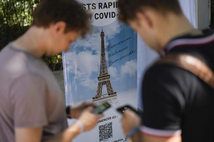 Du khách quét mã QR khai báo thông tin về Covid-19 tại điểm thăm quan nổi tiếng Tháp Eiffel ở Paris hôm 21/7 (Ảnh: AP)