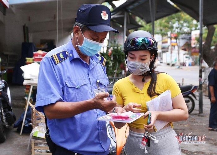 Hướng dẫn người dân quét thẻ đi chợ. Ảnh: Hồ Giáp