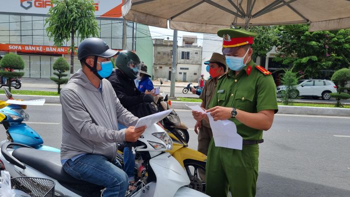 Lực lượng chức năng kiểm tra Giấy đi đường của người dân lưu thông trên đường Nguyễn Hữu Thọ. Ảnh: Thanh Trần. 