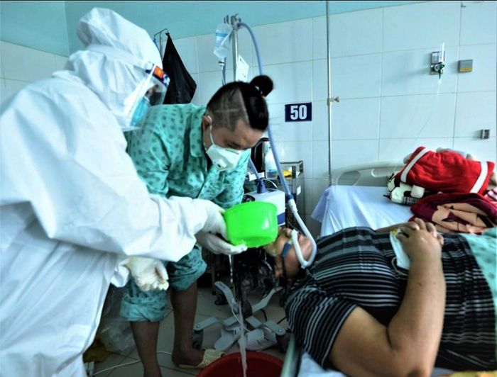  Nam thanh niên nhiệt tình gội đầu cho nữ bệnh nhân Covid-19. 