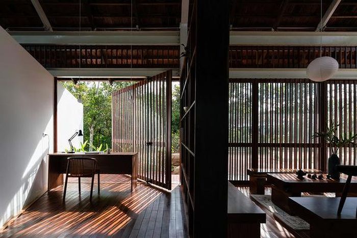 Góc làm việc tràn ngập thiên nhiên, được ngăn cách với không gian sinh hoạt chung bằng kệ gỗ để nhiều đồ trang trí. 