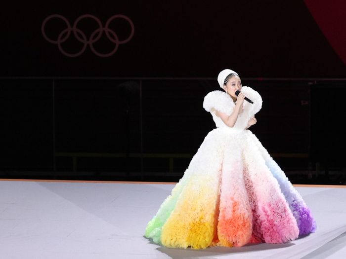 Nữ ca sĩ hát quốc ca Nhật Bản Misia để lại dấu ấn tại Lễ khai mạc Olympic Tokyo 2020 với trang phục cầu vồng. Theo Us Weekly, bộ váy được kết từ tác phẩm của nhà thiết kế Nhật Bản Tomo Koizumi. Anh đã chồng vô số lớp vải organza trắng rồi phun màu. Loại vải này có đặc tính mỏng, trơn, được làm từ lụa. Ảnh: Vogue.
