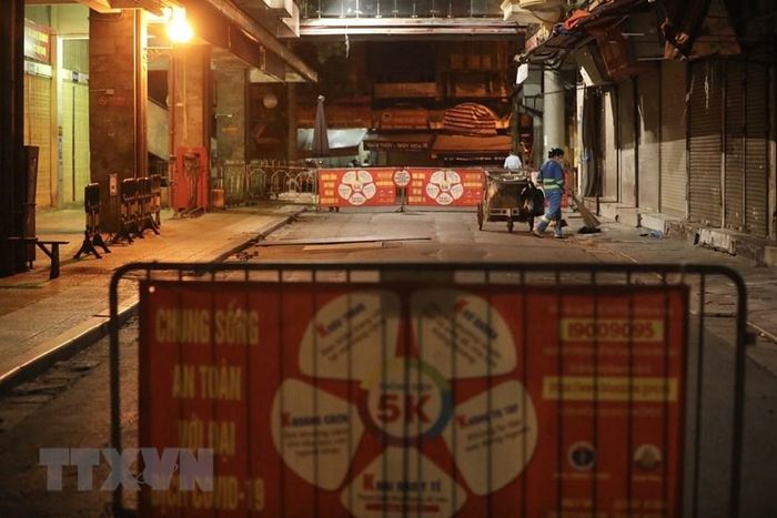 Đêm đến, khi nhà nhà yên giấc ngủ thì những người công nhân môi trường vẫn thầm lặng làm việc để giữ gìn vệ sinh đường phố. (Ảnh: Minh Quyết/TTXVN)