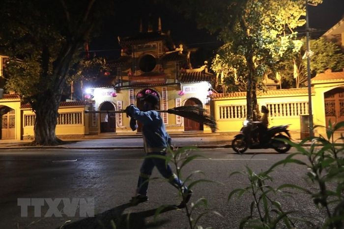 Trong thời gian giãn cách xã hội, người công nhân môi trường vẫn đảm bảo giữ gìn vệ sinh đường phố. (Ảnh: Minh Quyết/TTXVN)