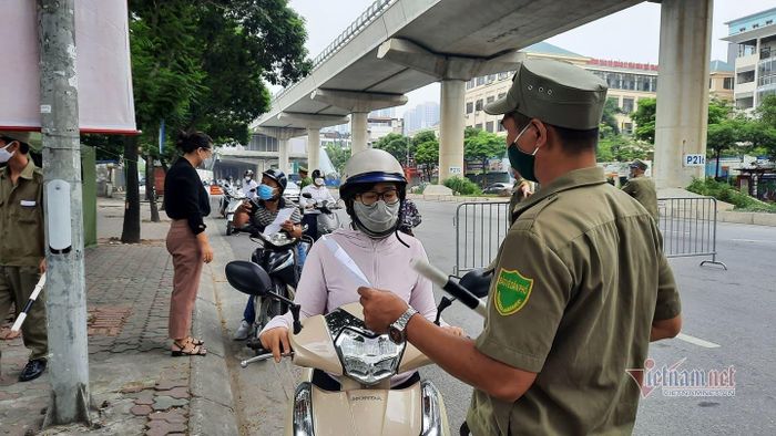 Kiểm tra giấy đi đường tại chốt của phường Mai Dịch, quận Cầu Giấy, Hà Nội sáng 9/8. Ảnh: Nhị Tiến
