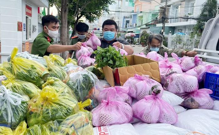  Cán bộ chiến sĩ Công an tỉnh An Giang trao tặng gạo, rau củ và nhu yếu phẩm đến từng nhà cho người dân.