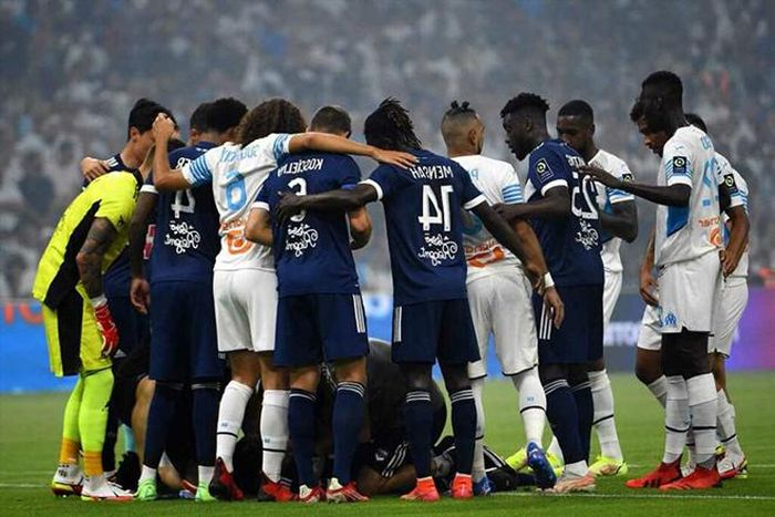 Cầu thủ hai đội Bordeaux và Marseille lập vòng tròn che chắn cho Kalu