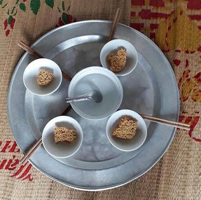 Khá khẩm hơn thì mâm cơm này có mì và một bát nước lọc ở giữa.