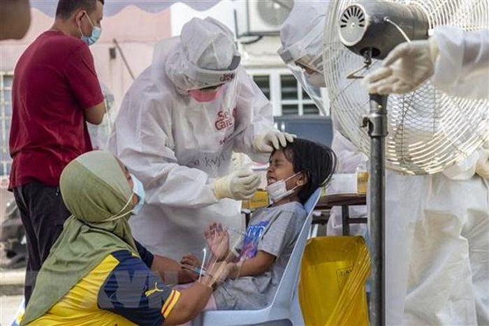 Nhân viên y tế lấy mẫu xét nghiệm COVID-19 cho trẻ em tại Subang, bang Selangor, Malaysia. (Ảnh: THX/TTXVN)