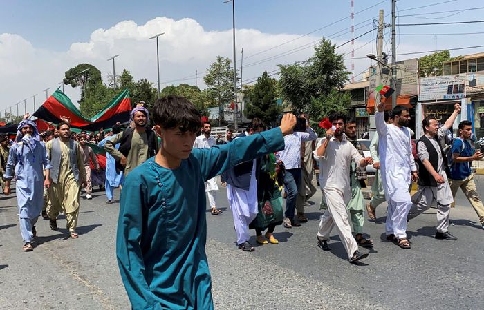  Người dân mang theo quốc kỳ tại cuộc biểu tình ở thủ đô Kabul, Afghanistan ngày 19/8. Trước đó một ngày, hàng chục người cũng tụ tập tại Jalalabad, miền Đông Afghanistan, và một thị trấn gần đó để hạ cờ của Taliban, theo AP. Đoạn video sau đó cho thấy Taliban nã đạn chỉ thiên và tấn công người dân bằng dùi cui để giải tán đám đông. Một quan chức y tế địa phương cho biết vụ bạo lực khiến một người thiệt mạng và 6 người bị thương. Ảnh: Reuters. 