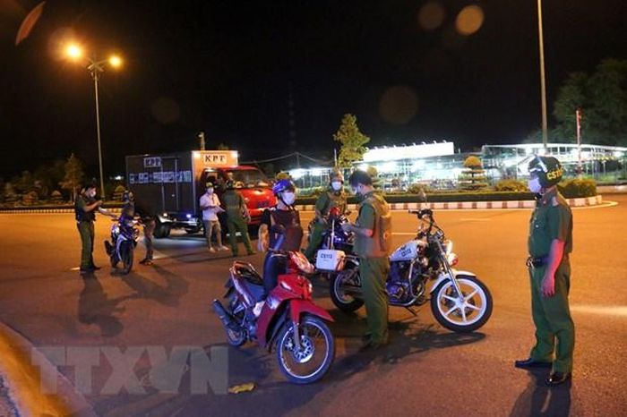 Lực lượng chức năng kiểm tra, nhắc nhở các trường hợp ra ngoài không đúng quy định. (Ảnh: Nguyễn Thanh/TTXVN)