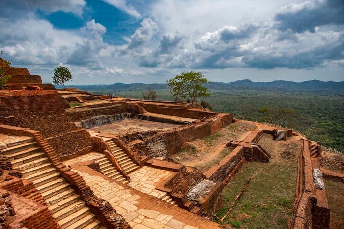  Quần thể cung điện trên đỉnh đá Sigiriya nhằm thể hiện sự giàu có và quyền lực của Kashyapa I, được xây dựng trên diện tích khoảng 1,5 ha với tổ hợp công trình phục vụ cuộc sống hoàng gia, hồ bơi nhân tạo và ngai vàng được tạc bằng đá tự nhiên. Ngoài ra, tại "pháo đài sư tử" còn có những hang động (Asana, Deraniyagala, Cobra Hood) và đền thờ trong thời kỳ Sigiriya trở thành tu viện Phật giáo. Với những giá trị lịch sử và nghệ thuật, Sigiriya đã được UNESCO công nhận là Di sản Văn hóa Thế giới vào năm 1982. Ảnh: Sri Lanka Holidays. 