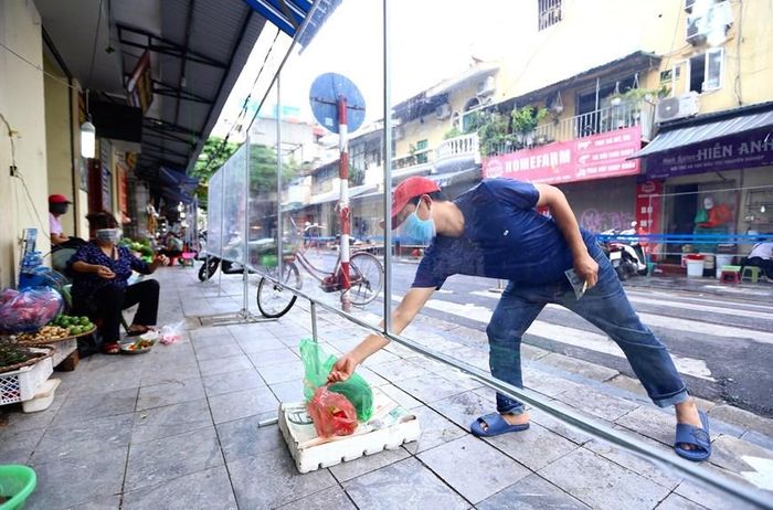 Để đảm bảo phòng dịch, người mua hàng và người bán đều không tiếp xúc trực tiếp. (Ảnh: Hoàng Hiếu/TTXVN)