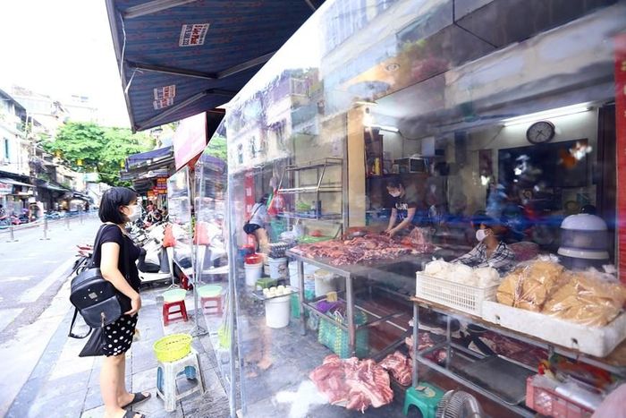 Tấm chắn giọt bắn được lắp ở tất cả các cửa hàng. (Ảnh: Hoàng Hiếu/TTXVN)