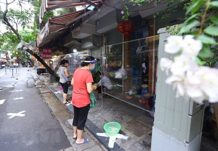  Người mua, bán đều đảm bảo giãn cách, không tiếp xúc trực tiếp. (Ảnh: Hoàng Hiếu/TTXVN)