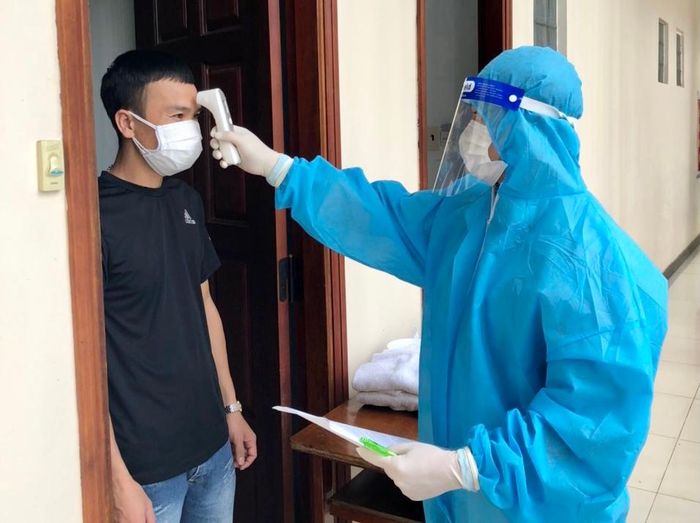 Nhân viên y tế đo thân nhiệt hàng ngày cho người cách ly tại Khách sạn Pleiku. Ảnh: Như Nguyện
