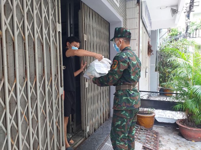 Phước cùng lực lượng bộ đội giao thực phẩm đến nhà người dân.