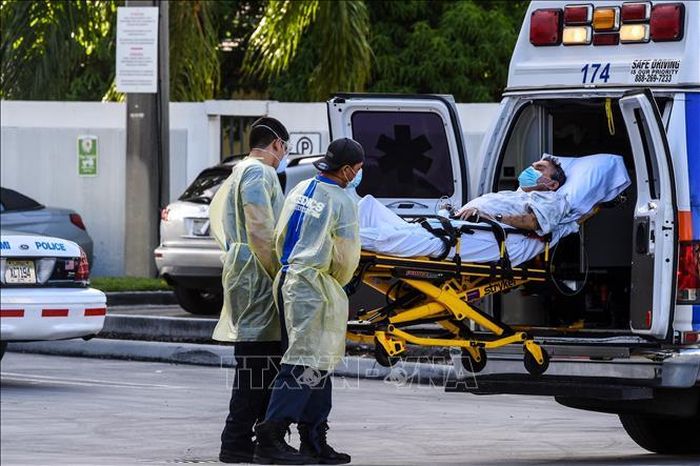 Nhân viên y tế chuyển bệnh nhân COVID-19 tới bệnh viện tại Coral Gables, gần Miami, Mỹ. Ảnh: AFP/ TTXVN