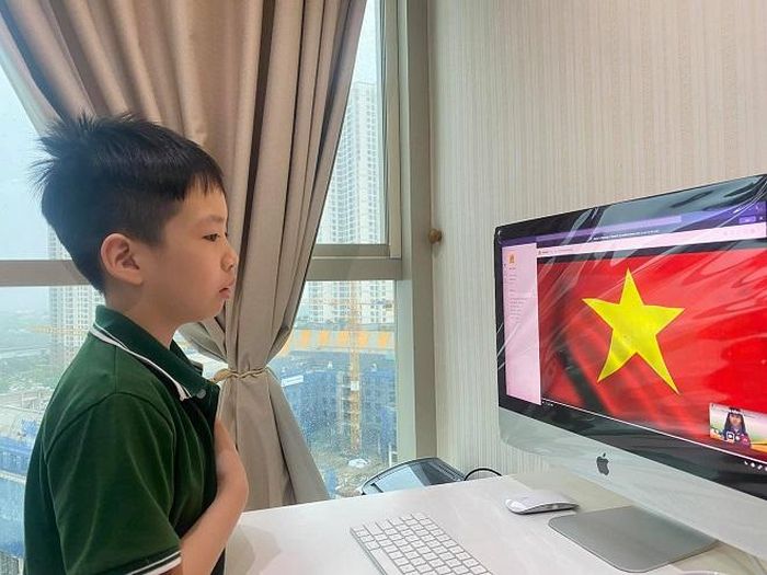 Trong bộ đồng phục của trường, con trai MC Mỹ Lan đã có buổi chào cờ trang nghiêm trước màn hình máy tính
