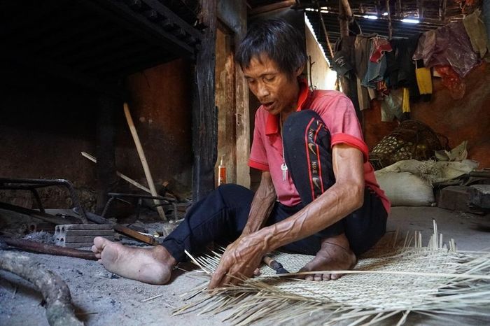 “Người rừng” Hồ Văn Lang trong những ngày tháng lâm trọng bệnh, vẫn cố gắng đan nông cụ để kiếm sống - ảnh N.N