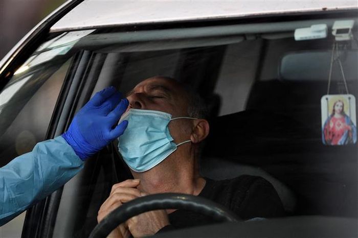 Nhân viên y tế lấy mẫu xét nghiệm COVID-19 cho người dân tại Sydney, Australia. Ảnh: AFP/TTXVN