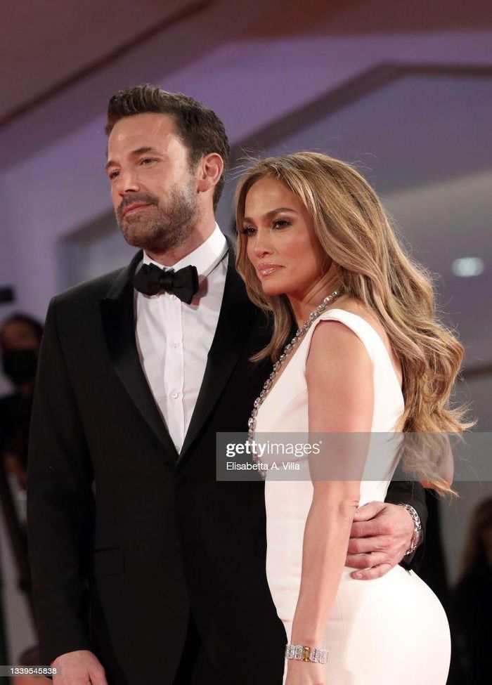 Giống với lần xuất hiện ở Met Gala, J. Lo và tài tử Gone Girl liên tục thể hiện tình cảm, theo Us Weekly. Tuy nhiên, trái với trang phục lông vũ rườm rà, J. Lo ghi điểm ở LHP Venice với váy trắng có phần ngực khoét sâu, vòng cổ đính đá. Daily Mail đưa tin giọng ca On the Floor ghi điểm từ phong cách, kiểu trang điểm đến vóc dáng thon gọn ở tuổi 52. Ảnh: Getty.