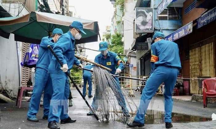 Các lực lượng thu dọn rào chắn trên đường Nguyễn Thiện Thuật (Quận 3, Tp. Hồ Chí Minh). Ảnh: Hồng Giang - TTXVN