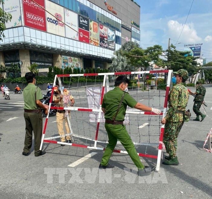 Lực lượng chức năng gỡ chốt trên tuyến đường Điện Biên Phú (quận Bình Thạnh, Tp. Hồ Chí Minh). Ảnh: Xuân Tình - TTXVN