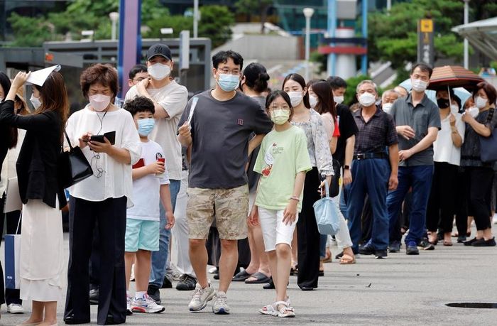 Người dân xếp hàng chờ tiêm chủng tại một nhà ga xe lửa ở Seoul, Hàn Quốc. Ảnh: Reuters.