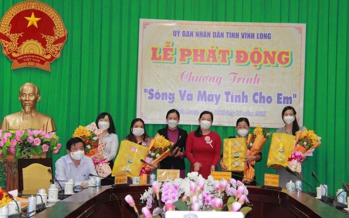Lãnh đạo Sở Giáo dục và Đào tạo tỉnh Vĩnh Long tặng hoa cảm ơn các tổ chức, cá nhân đã hỗ trợ cho các em học sinh.
