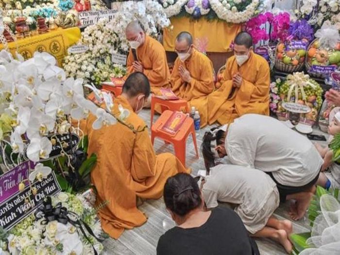 Hồ Văn Cường đội khăn tang, cúi đầu khấn mẹ nuôi. Ảnh: Yan