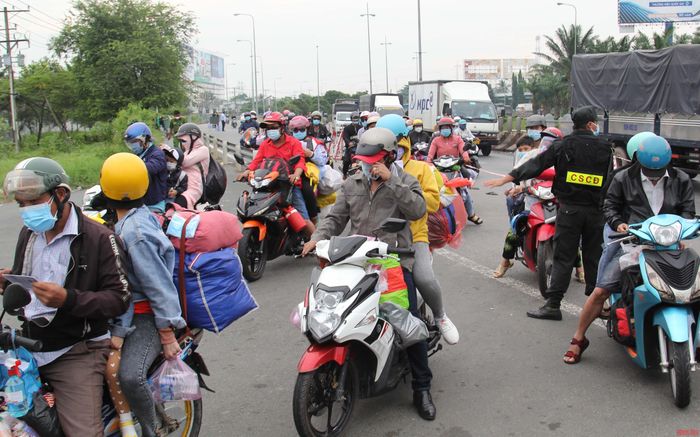 Tại chốt kiểm soát số 1 tại chân cầu Mỹ Thuận, phía bờ Vĩnh Long, từng xe nối đuôi nhau làm thủ tục qua chốt.