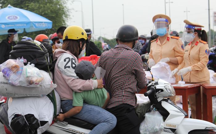 Cảnh sát giao thông hỗ trợ thức ăn, nước uống cho người đi đường.