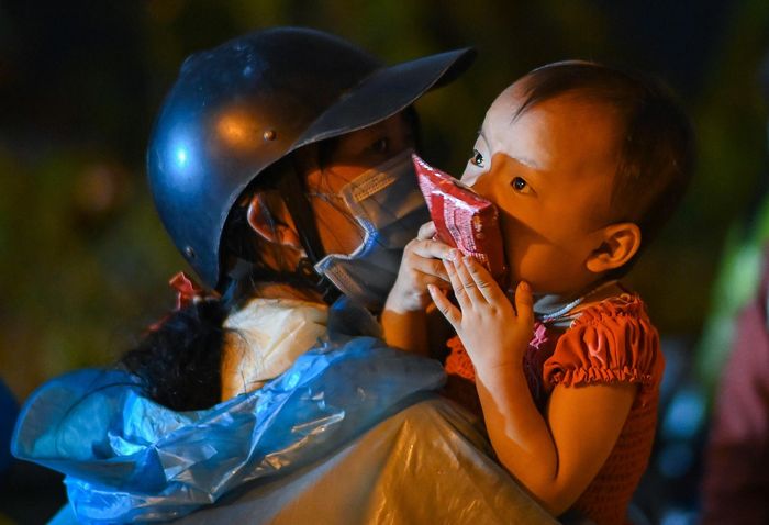  Chị Đàm Thị Nở (quê Hà Giang) cùng chồng và con gái vào miền Nam làm công nhân được hơn nửa năm thì 3 tháng phải chịu cảnh thất nghiệp. Khi Bình Dương nới lỏng giãn cách, ngày 2/10, gia đình chị lại ròng rã trên xe máy để về quê. "Cũng may vì còn chút tiền tiết kiệm, vợ chồng tôi vẫn đủ ăn trong lúc giãn cách, nhưng lâu ngày cũng hết, đành phải về quê. Hôm qua, Nghệ An mưa to lắm, tôi rất lo con nhỏ dễ bị cảm, ốm. Giờ cả nhà chỉ mong sớm được trở về quê với gia đình thôi", chị Nở nói. 