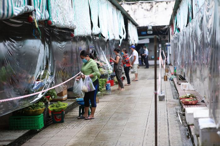  Chợ Bến Thành chủ động lắp vách ngăn và giăng dây để giữ khoảng cách cho các tiểu thương với nhau và khoảng cách giữa người mua và người bán. Chị Oanh (áo xanh) cho biết đã có thẻ xanh nên an tâm đi chợ. Chị mua được nhiều rau củ và hàng hóa. 