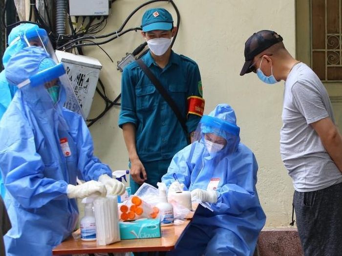 Người dân phường Hàng Bông khai báo y tế trước khi lấy mẫu xét nghiệm. Ảnh: Hoàng Hiếu - TTXVN